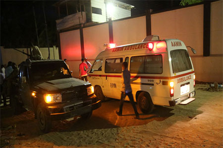 A man walks past an ambulance and armed security forces at the scene of an attack outside an hotel in Mogadishu, Somalia June 14, 2017