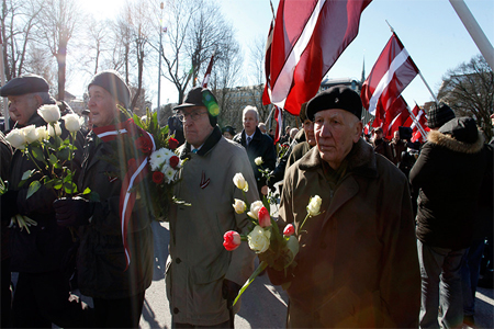 Men holding flowers take part in the annual procession commemorating the Latvian Waffen-SS (Schutzstaffel) unit, also known as the Legionnaires, in Riga