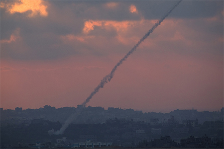Smoke trails are seen as rockets are launched from the Gaza Strip towards Israel as seen from the Israeli border