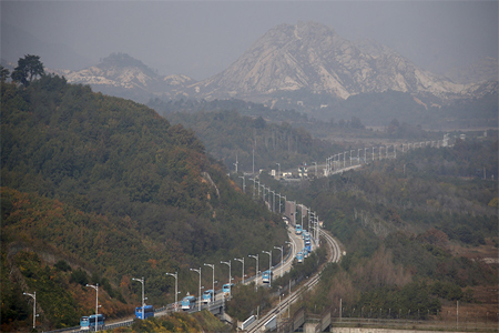 Buses transporting South Korean participants for reunion travel on road leading to North Korea's Mount Kumgang resort, in DMZ separating two Koreas in picture taken from the Unification Observatory, Goseong, South Korea