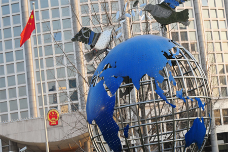 The Chinese flag flies beside a globe of the world outside the Foreign Ministry headquarters in Beijing