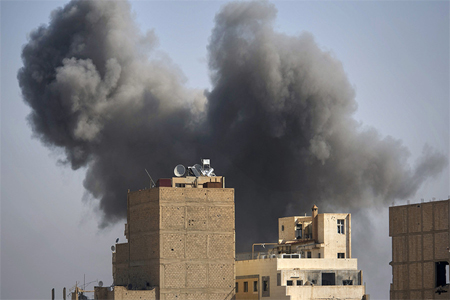 Smoke rises from the site of a missile attack in Hawiqah neighbourhood in the eastern Syrian town of Deir Ezzor