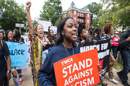 A woman marches with a ''stand against racism'' protest sign during March for Racial Justice in Washington, D.C.