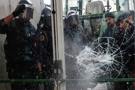Spanish Civil Guard officers break through a door at a polling station for the banned independence referendum where Catalan President Carles Puigdemont was supposed to vote in Sant Julia de Ramis, Spain October 1, 2017. © Juan Medina / Reuters
