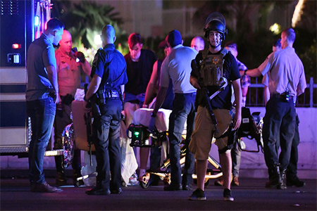 Police officers stand by as medical personnel tend to a person on Tropicana Ave. near Las Vegas Boulevard after a mass shooting at a country music festival nearby on October 2, 2017 in Las Vegas, Nevada.
