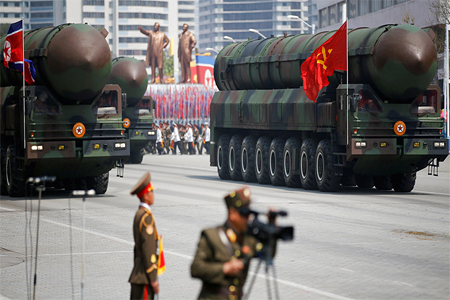 FILE PHOTO: Intercontinental ballistic missiles (ICBM) are driven past the stand with North Korean leader Kim Jong Un during a military parade in Pyongyang.