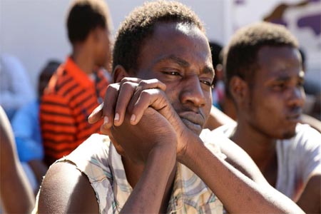 Sudanese migrants sit at a detention center before their voluntary return to their country, in Tripoli, Libya, on September 14, 2017.