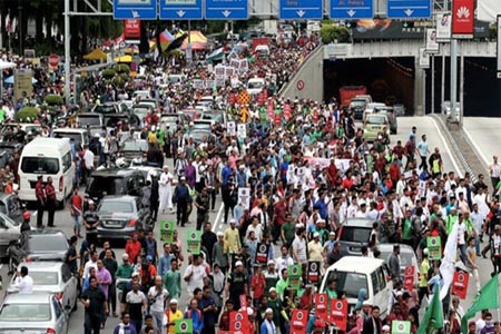 An ultra Orthodox Jewish man rides a bicycle as US and Israeli flags are projected on the walls of Jerusalem’s old city on Dec. 6, 2017.