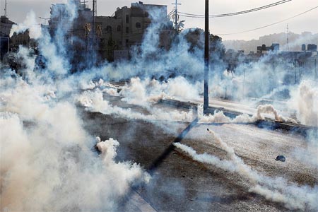 Israeli forces fire gas canisters at Palestinian protesters during a protest in the West Bank city of Bethlehem, December 10, 2017