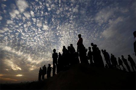 Palestinian protesters watch on during clashes with Israeli forces near the border fence with Israel, east of Gaza on December 12, 2017.