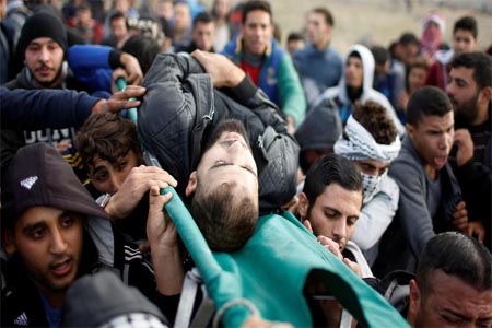 A wounded Palestinian is evacuated during clashes with Israeli troops at a protest near the border with Israel in the east of Gaza City on December 15, 2017.