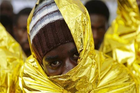 a migrant waiting to disembark from a Coast Guard ship in the Sicilian harbour of Messina, Italy.