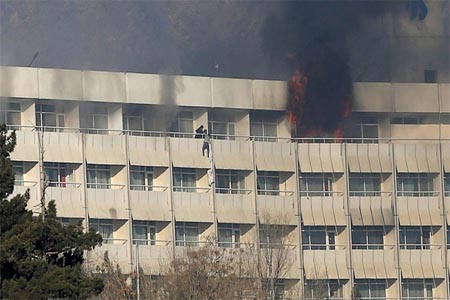 A man tries to escape from a balcony at Kabul's Intercontinental Hotel during an attack by gunmen in Kabul.