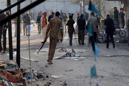 Pakistani security officials inspecting the site of a bomb attack.