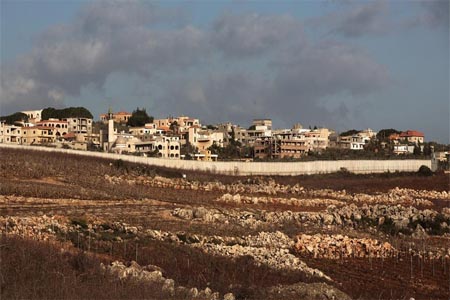 A wall stands next to the southern Lebanese town of Kfar Kila along the Lebanon-Israel border.