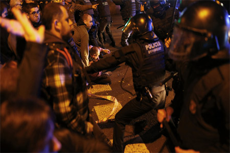 Riot police officers scuffle with demonstrators in Barcelona on March 23.