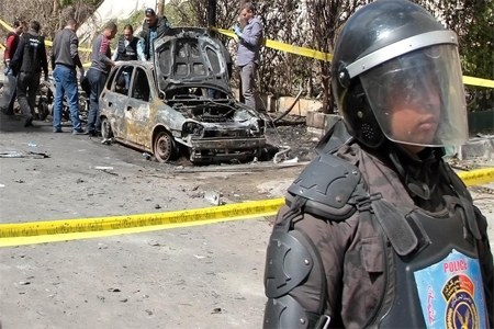 A security personnel stands guard, during the forensics team investigation of a bombing in Alexandria on March 24, 2018.