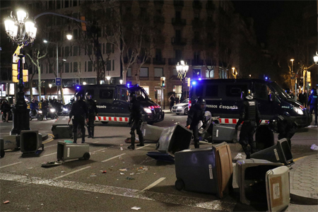 Catalan police remove trash bins used as barricades by protesters during skirmishes in Barcelona, Spain March 25, 2018