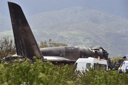 Rescuers are seen around the wreckage of an Algerian army plane which crashed near the Boufarik airbase from where the plane had taken off