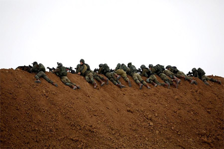 Israeli soldiers are seen next to the border fence on the Israeli side of the border with the northern Gaza Strip.