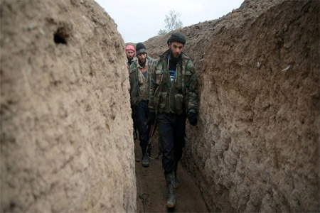 Syrian militants walk inside a trench in the eastern Damascus suburb of Ghouta, Syria, on January 2, 2017.
