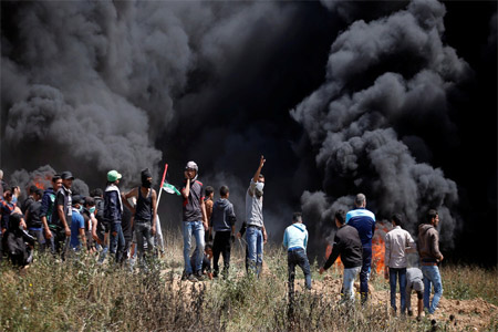 Palestinian demonstrators gather at the Israel-Gaza border during clashes with Israeli troops east of Gaza City, on April 6, 2018.