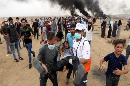 A wounded demonstrator is evacuated during a protest where Palestinians demand the right to return to their homeland.