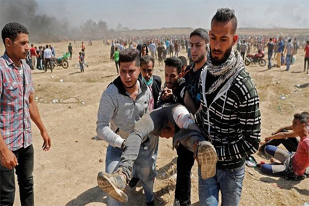 Palestinians carry a demonstrator injured during clashes with Israeli forces near the border between the Gaza strip.