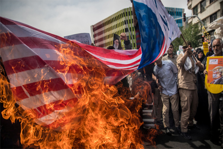 Iranians burn a US flag during a protest against President Trump's decision to pull out of the nuclear deal.