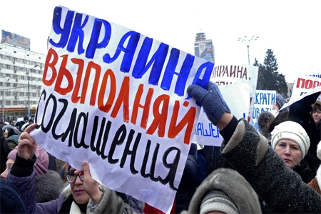 "Ukraine, honor the agreements" reads the posted carried by Donetsk residents at a rally