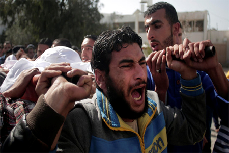 Palestinian mourners chant angry slogans as they carry the body of fisherman Tawfiq Abu Riala, 32, during his funeral in Gaza City