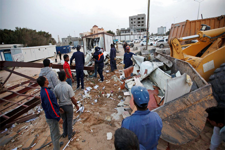 People are seen at the scene of an explosion at a checkpoint at the eastern entrance to the city of Janzour in Tripoli March 15, 2015. (Reuters)