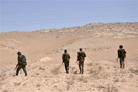 جنود سوريون يتمركزون خلال اشتباكات مع "داعش" قرب تدمر أمس (ا ف ب)