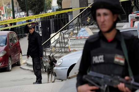 An Egyptian policeman stands alert as another member of bomb squad handle a sniffer dog after a bomb blast near the Egyptian High Court, in downtown Cairo, Egypt, Monday, March 2, 2015. (AP)