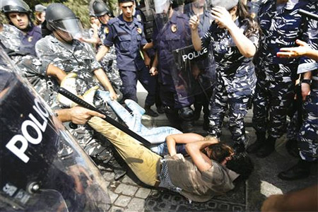 رجال الأمن يجرّون شاباً وفتاة من المتظاهرين في ساحة الشهداء امس (مصطفى جمال الدين)