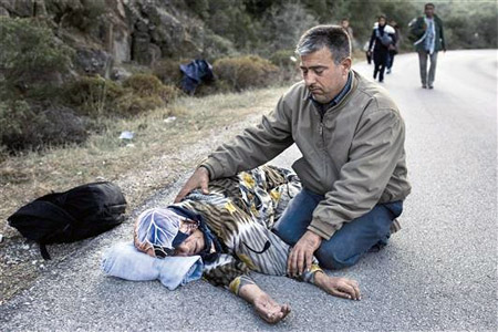 سوري يواسي والدته التي انهارت من التعب بعد وصولها الى اليونان امس (ا ف ب)