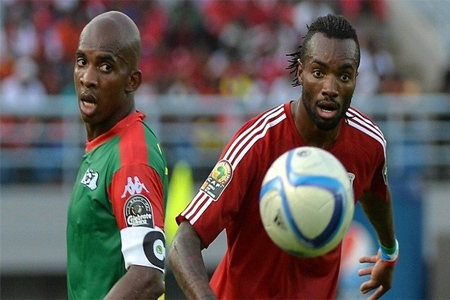 لاعب خط وسط غينيا الاستوائية خافيير بالبوا ضد لاعب بوركينا فاسو تشارلز كابوري في كأس الأمم الأفريقية