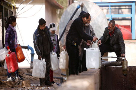 People queue as they fill containers with water in the government controlled al-Rabwah area, a suburb of Damascus, Syria January 10, 2017. © Omar Sanadiki / Reuters
