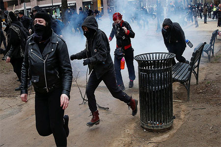 Activists race after being hit by a stun grenade while protesting against U.S. President-elect Donald Trump on the sidelines of the inauguration in Washington, U.S., January 20, 2017. © Adrees Latif / Reuters