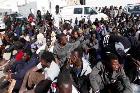 FILE PHOTO: African migrant sit at a detention camp in Tripoli, Libya