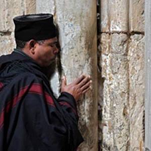 مسيحيون وسياح يؤدون صلواتهم على باب كنيسة القيامة المغلقة لليوم الثاني